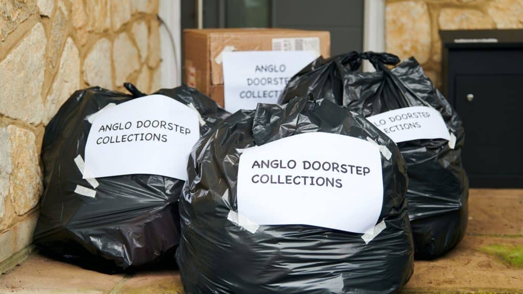 Bags of donations on the doorstep, labelled for anglo doorstep collections.