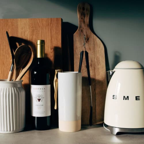 Kettle, bottle and utensils in work surface.